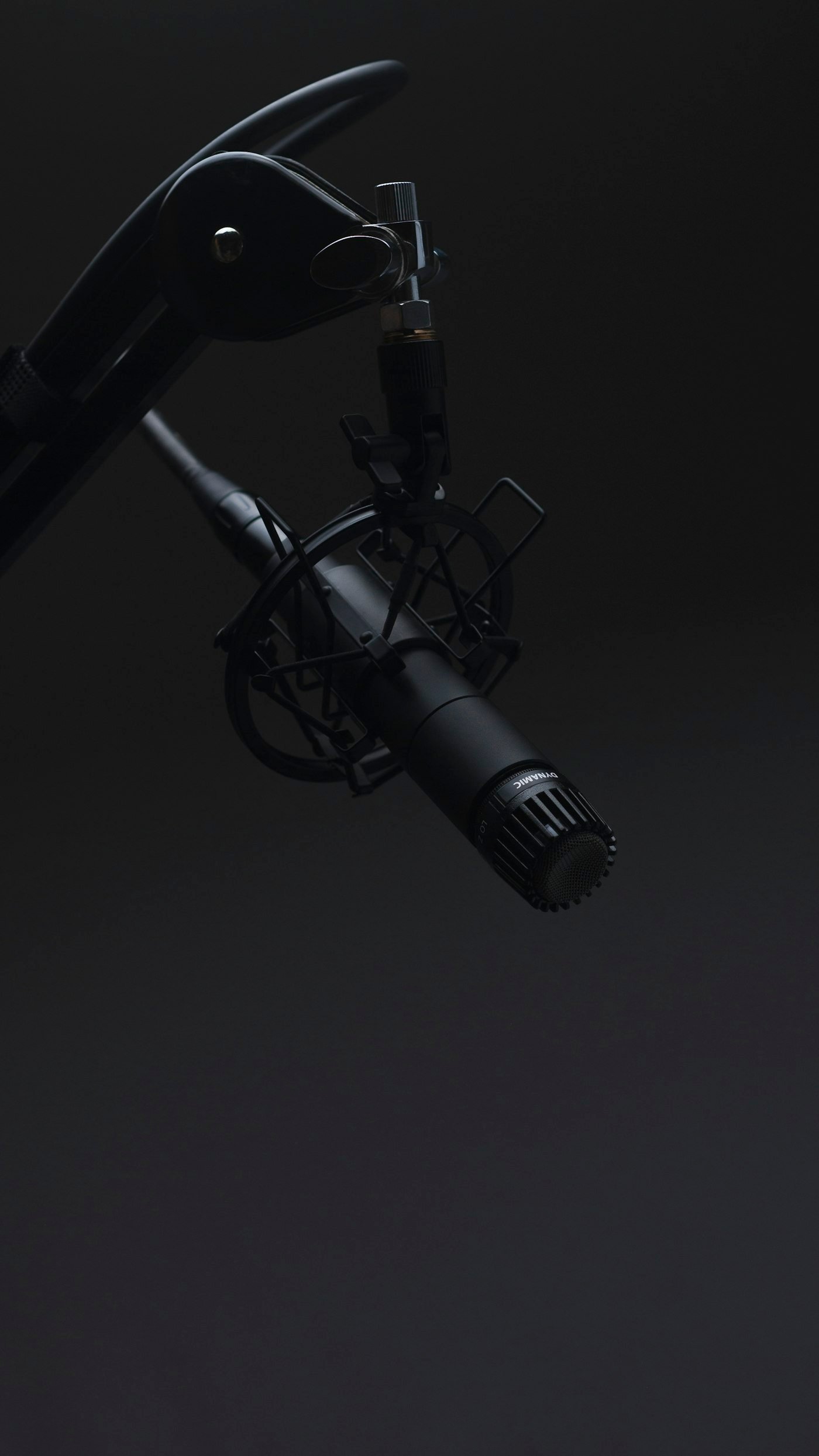 A studio microphone in a dark broadcast booth